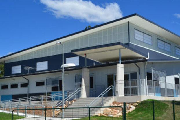 A modern and new school building with a large, open facade in blue tones.